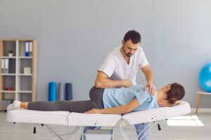 A chiropractor performing a gentle spinal adjustment on a patient in a bright, comfortable clinic.