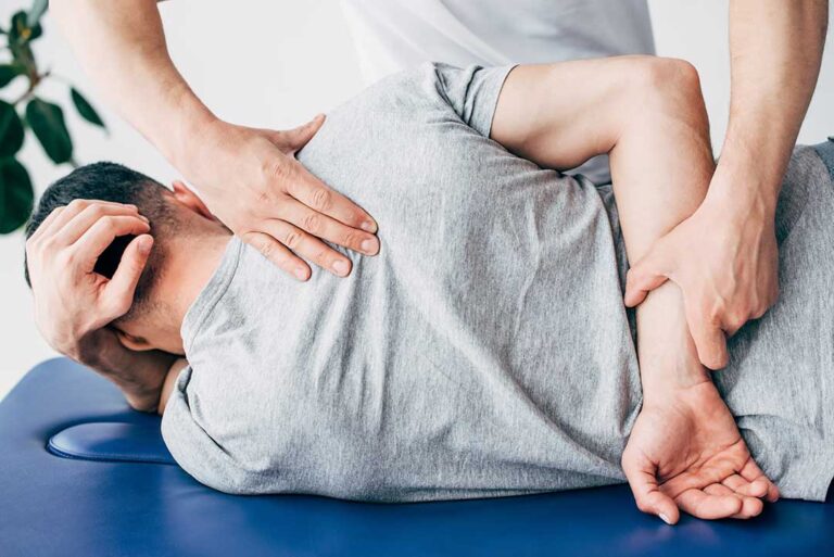 A person gently stretching their back at home in a bright, comfortable living space.